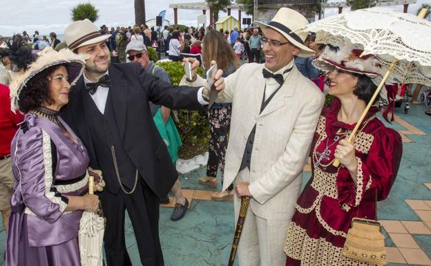 Cuatro figurantes vestidos de época se toman fotos con sus teléfonos móviles.