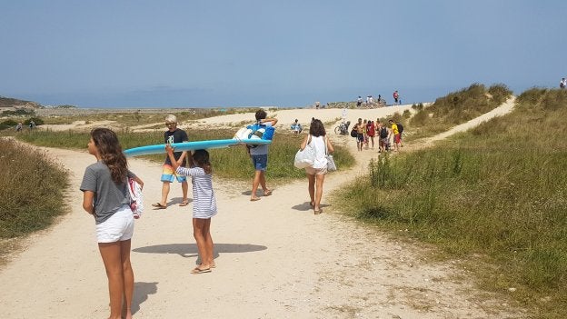 Numerosas personas transitan entre el aparcamiento y las dunas generando numerosos caminos que provocan profundas brechas en las dunas.