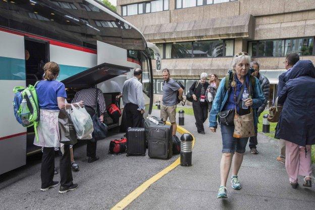 Un grupo de turistas descarga sus maletas de un autobús a su llegada a un hotel de Santander