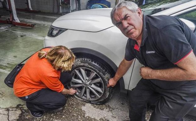 María Luisa y Gonzalo muestran una de las tres ruedas pinchadas en un Nissan Qashqai.