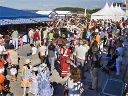 Cientos de personas se acercaron ayer a la terraza de la Primera Playa para recorrer las casetas y participar en las primeras actividades de los Baños de Ola. / ROBERTO RUIZ/