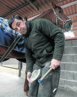 Muguerza herrando uno de los caballos de su establo./