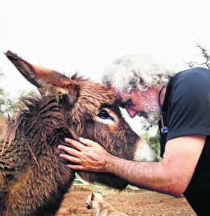 Corbacho acaricia a uno de los burros que viven con él en La Alcornocosa. ::
FRANCISCO APAOLAZA/