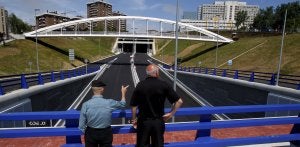 Dos viandantes observan cómo se encuentra el Distribuidor, prácticamente acabado, desde la rotonda de Valdecilla frente a la entrada del falso túnel. :: CELEDONIO/