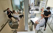Una de las peluquerías Macavi, de Santander, ayer tras reabrir, atiende a varias clientas a la vez, manteniendo las distancias entre ellas./FOTOGRAFÍAS: